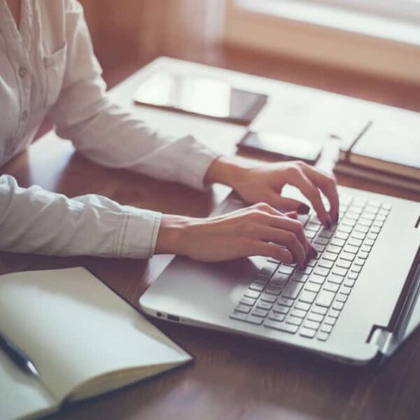 close up of person at desk using computer