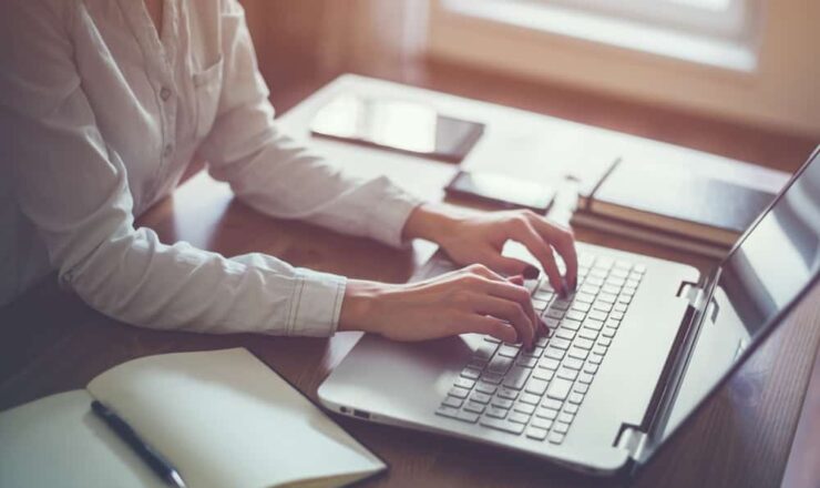 close up of person at desk using computer