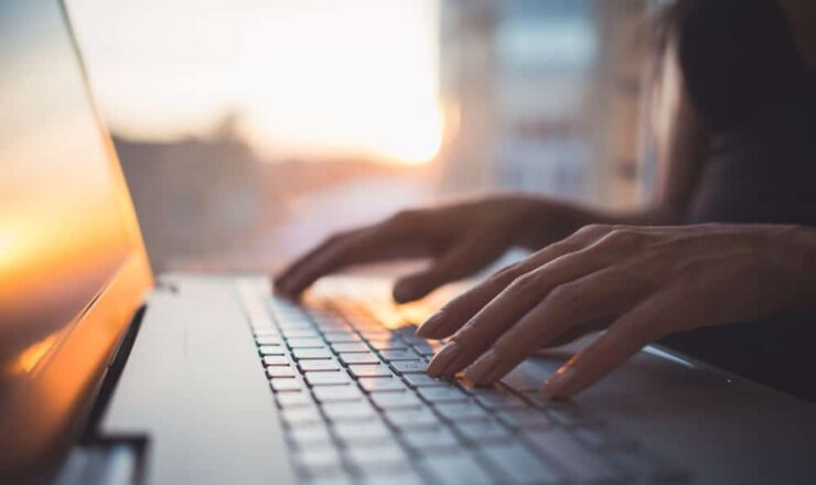 close up of person typing on a computer